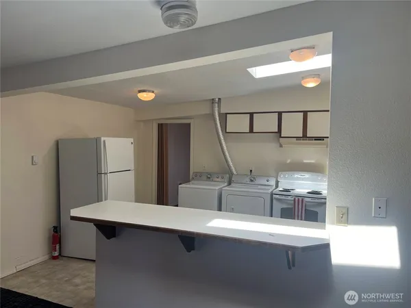 a view of a kitchen with kitchen island a sink wooden floor and glass door