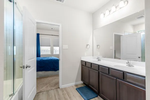 a en suite bathroom with a double vanity sink a mirror and a shower