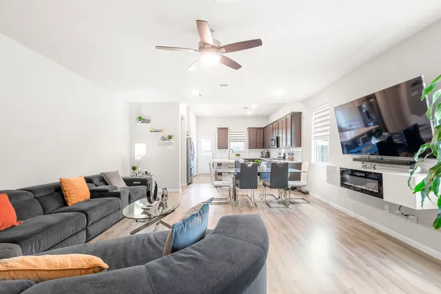 a living room with furniture kitchen view and a flat screen tv