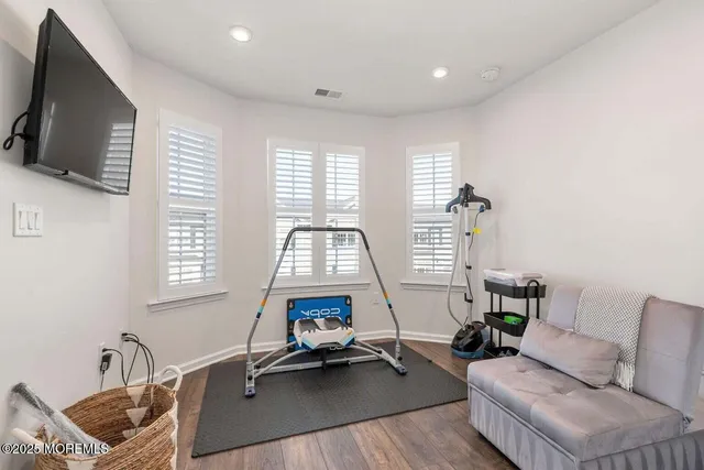 a living room with furniture a flat screen tv and a large window