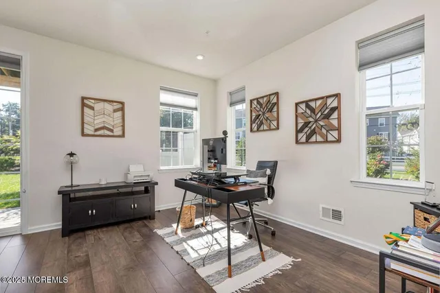a view of a workspace with furniture and a window