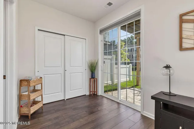 a view of a hallway with wooden floor and windows