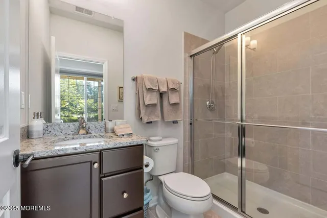a bathroom with a granite countertop sink toilet and shower