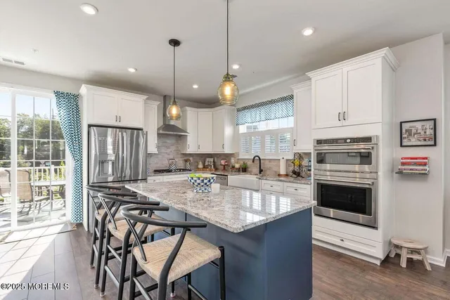a kitchen with stainless steel appliances granite countertop a stove refrigerator sink and cabinets