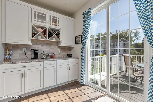 a kitchen with granite countertop white cabinets and window