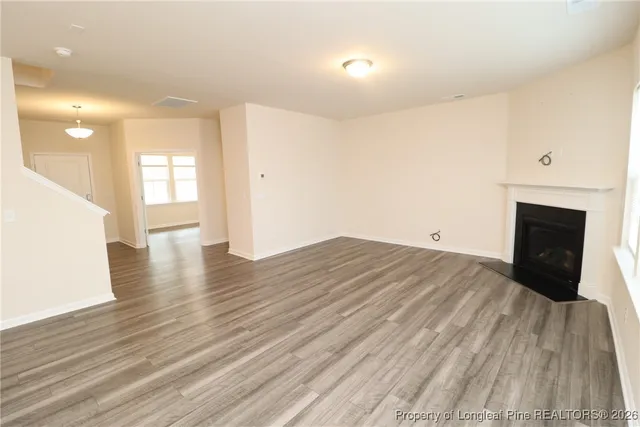 a view of empty room with wooden floor and fireplace