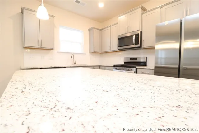 a kitchen with stainless steel appliances a refrigerator sink and microwave