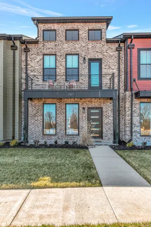 front view of a brick house with a yard