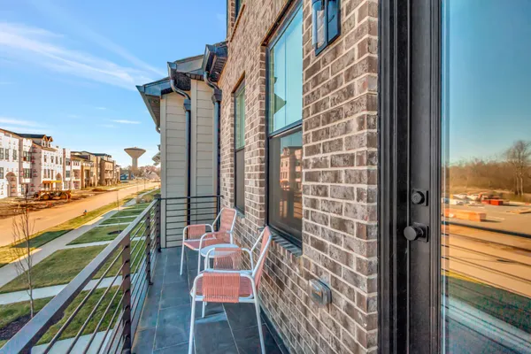 a balcony view with two chairs and a potted plant on a table