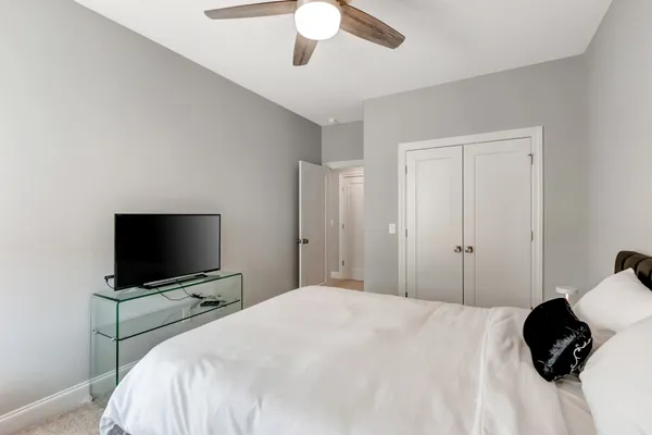 a bedroom with a bed and a flat tv screen on dresser