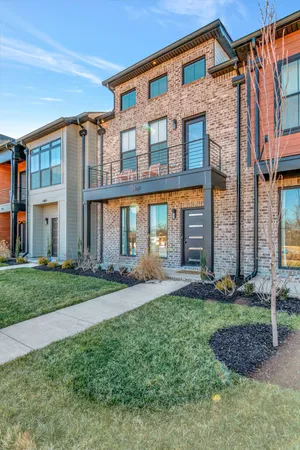 a front view of a house with a yard and trees