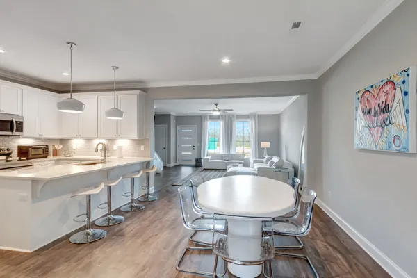 a kitchen with a table chairs sink and cabinets