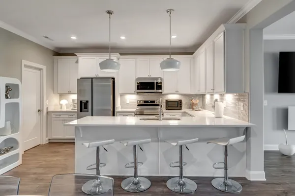 a kitchen with stainless steel appliances granite countertop a stove refrigerator and microwave