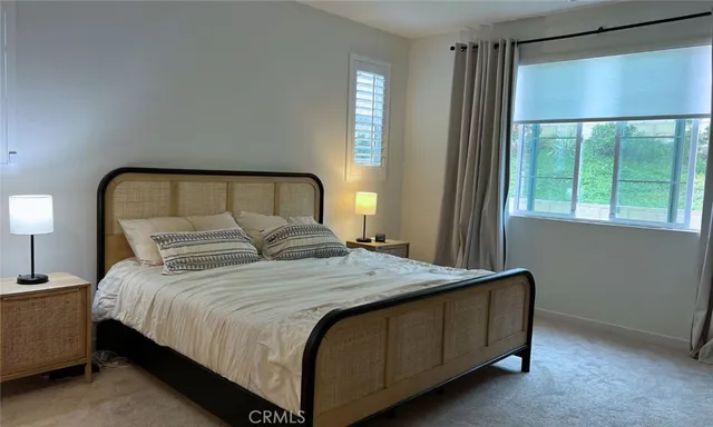 a large bed sitting in a bedroom next to a window