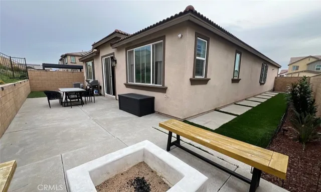 a backyard of a house with chairs and a table