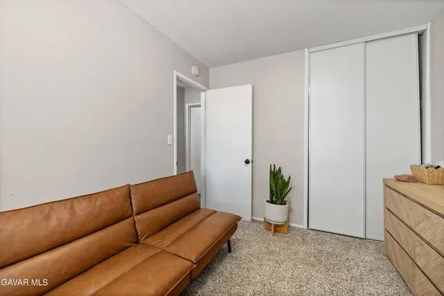 a living room with a couch and a potted plant