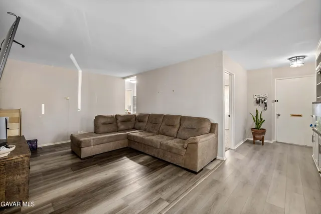 a living room with furniture and a wooden floor