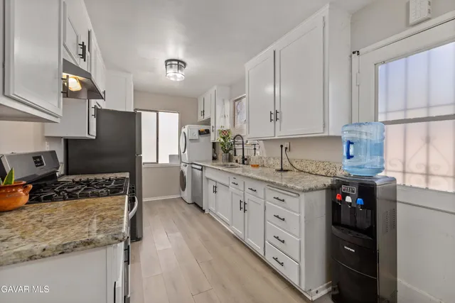 a kitchen with stainless steel appliances granite countertop a stove a sink and a refrigerator