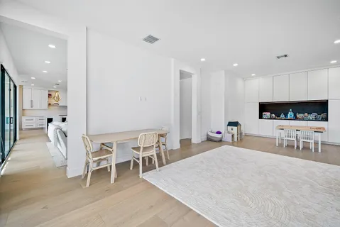 a living room with furniture a flat screen tv and kitchen view