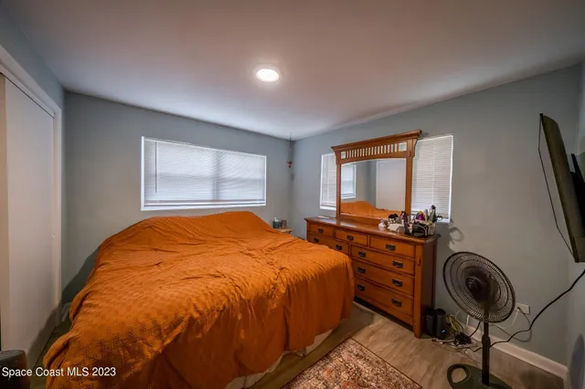 a bedroom with a bed and a flat tv screen on the dresser