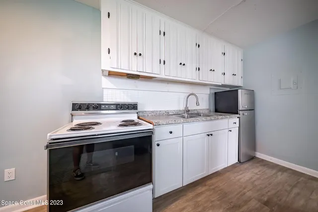 a kitchen with granite countertop white cabinets and stainless steel appliances
