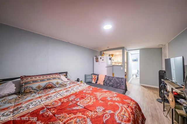 a bedroom with a bed and a flat tv screen on a dresser