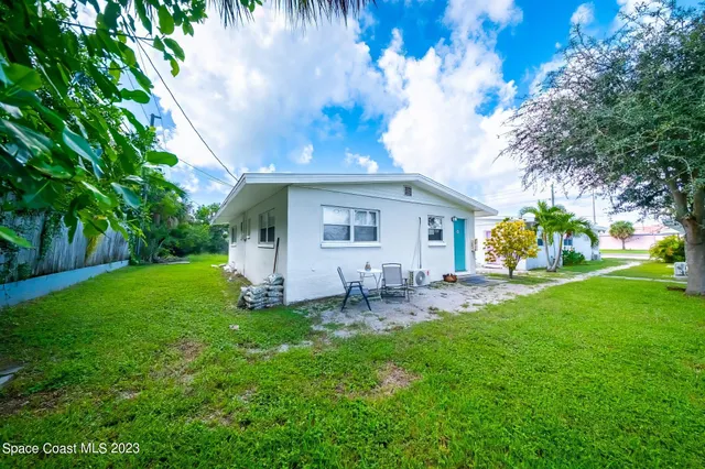 a view of a house with a yard and sitting area