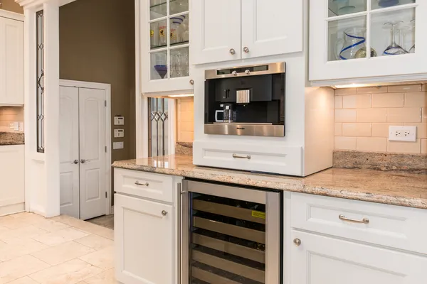 a kitchen with granite countertop white cabinets and white appliances