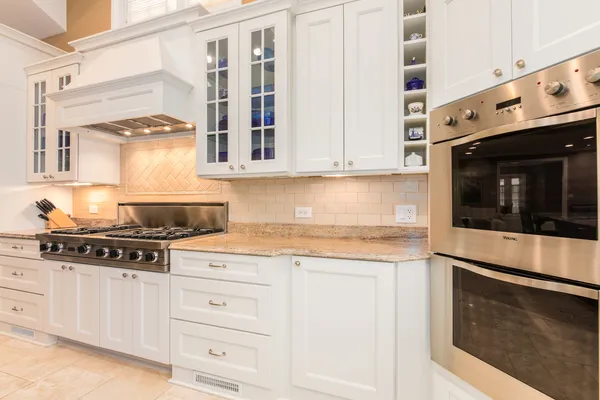 a kitchen with stainless steel appliances granite countertop white cabinets and a stove