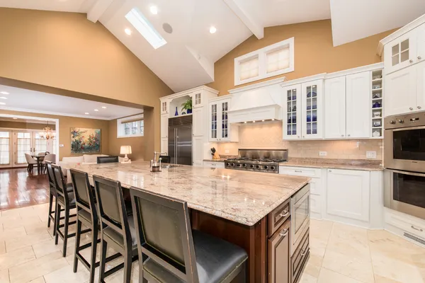 a large kitchen with granite countertop lots of counter top space and stainless steel appliances