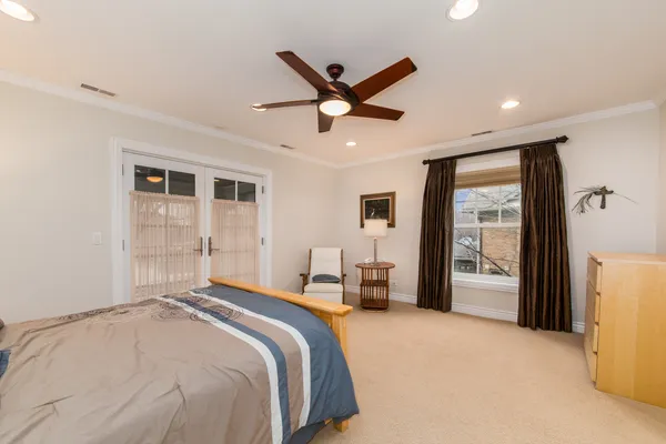 a bedroom with a large bed and a chandelier