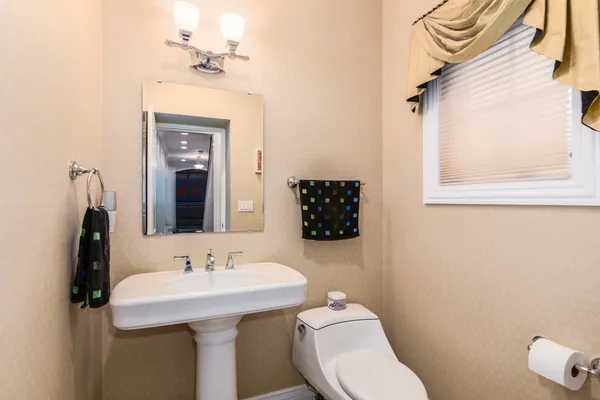 a bathroom with a sink a toilet and mirror