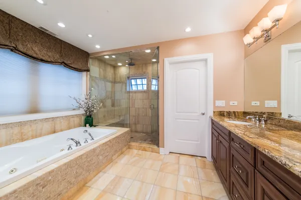 a spacious bathroom with a sink a large mirror and a vanity