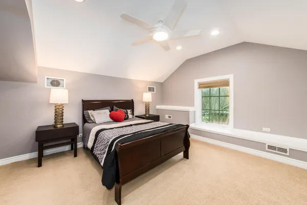 a bedroom with a large bed and a chandelier
