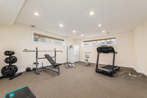 a backyard of a house with table and chairs plants and large tree