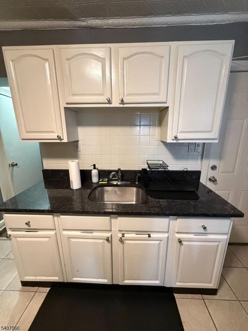 243 Lake Street Newark, NJ 07104 - Photo 13 of 16 a kitchen with granite countertop white cabinets and sink