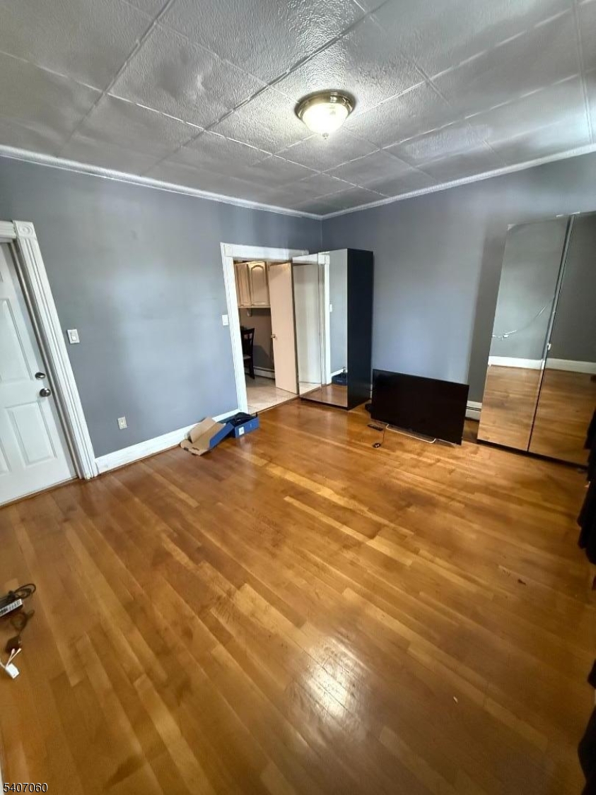 243 Lake Street Newark, NJ 07104 - Photo 10 of 16 a view of an empty room with window and wooden floor