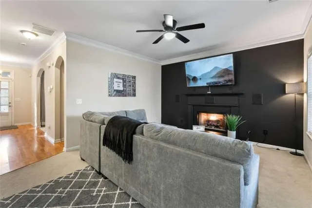 a living room with furniture fireplace and a large window