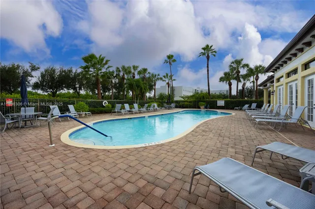 a patio with table and chairs and potted plants