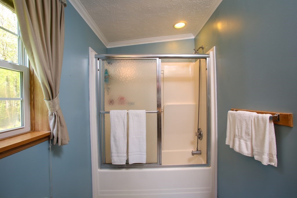 169 Ford Hill Road Rowe, MA 01367 - Photo 15 of 24 a bathroom with a glass shower door and a window