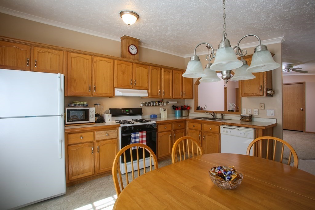 169 Ford Hill Road Rowe, MA 01367 - Photo 9 of 24 a kitchen with refrigerator a stove a sink dishwasher and a dining table with wooden floor