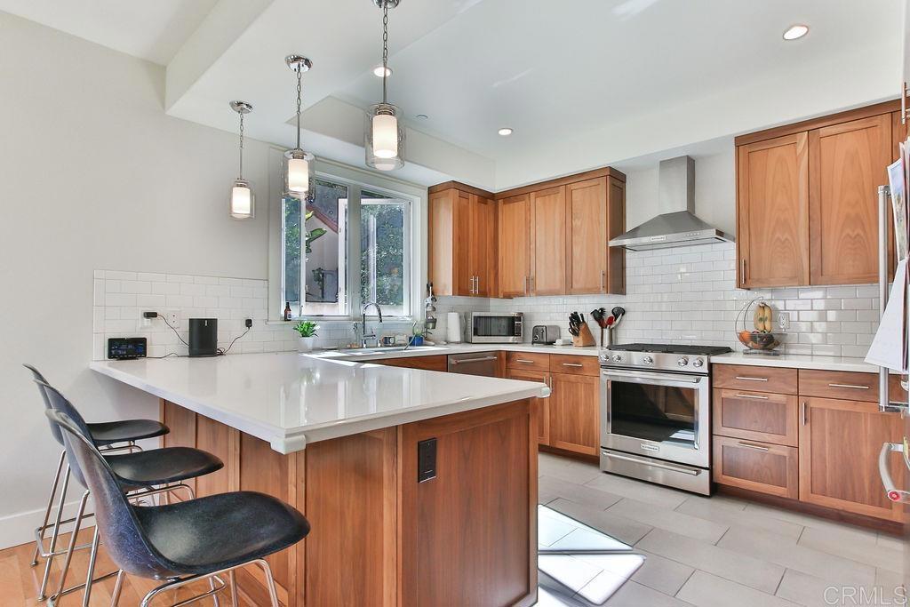 573 H Coronado, CA 92118 - Photo 16 of 39 a kitchen with a stove a sink and a refrigerator