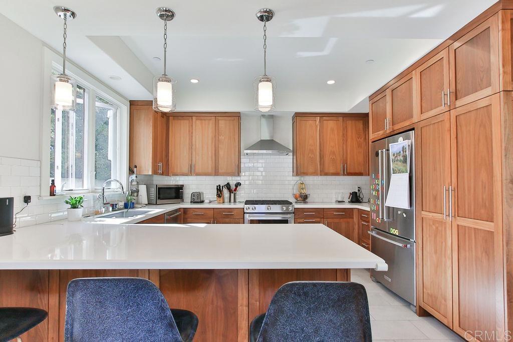 573 H Coronado, CA 92118 - Photo 18 of 39 a kitchen with stainless steel appliances a sink a stove a refrigerator a center island and a cabinets