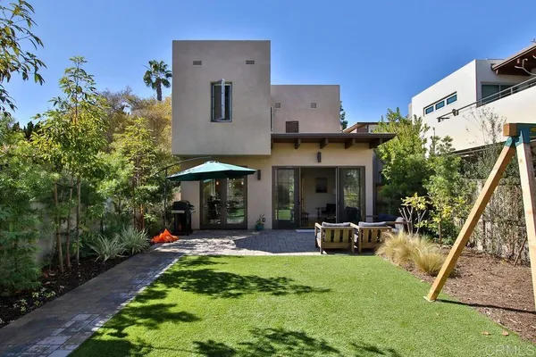 a view of the house with backyard and sitting area