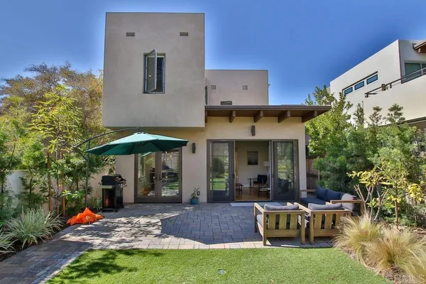 a view of a house with backyard sitting area and garden