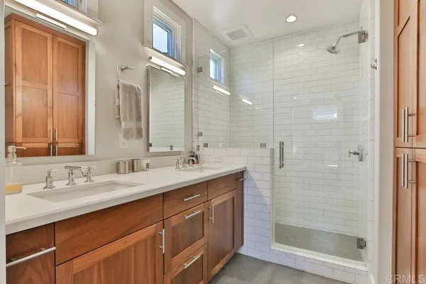 a bathroom with a double vanity sink mirror and shower