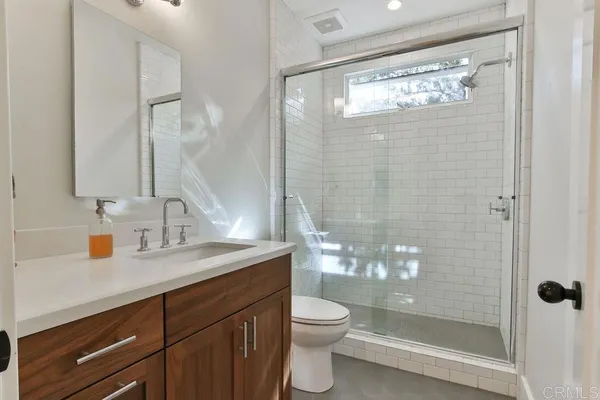 a bathroom with a granite countertop sink mirror toilet and shower