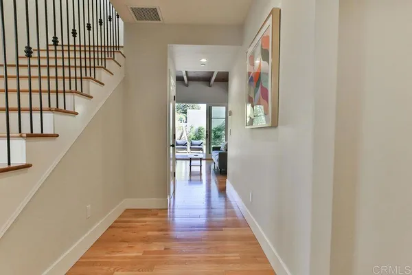 a view of a hallway with wooden floor and staircase