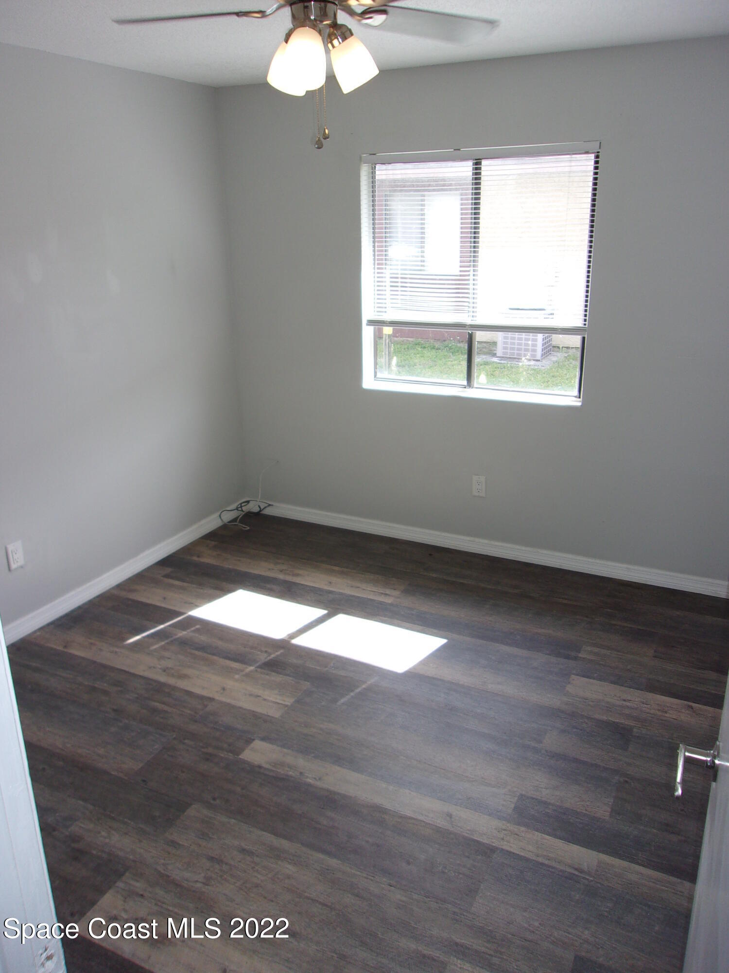 1050 North Fiske Boulevard, Unit 406 Cocoa, FL 32922 - Photo 7 of 11 an empty room with wooden floor and windows