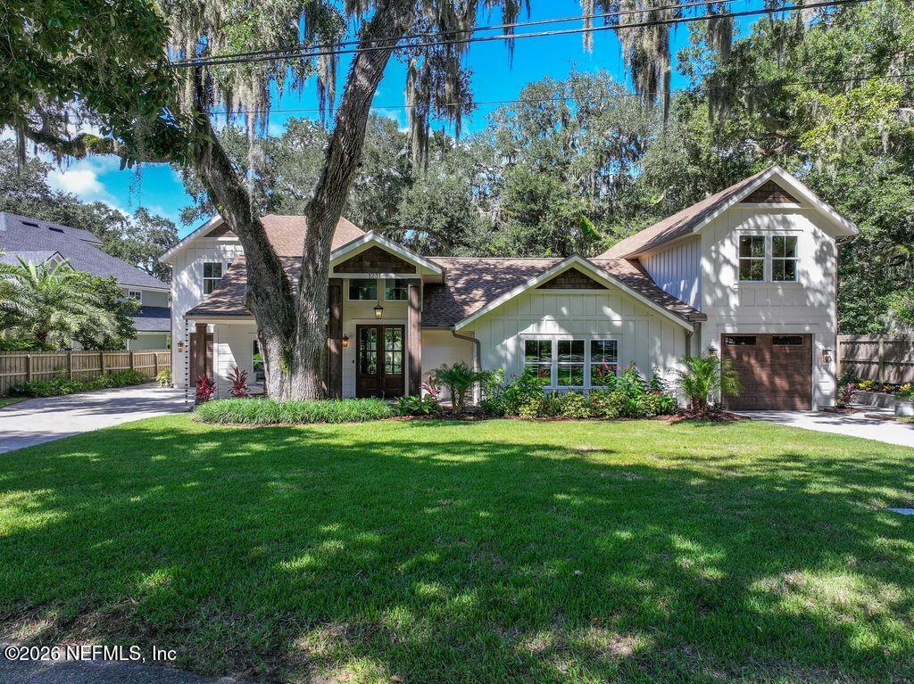 a front view of a house with a yard and trees